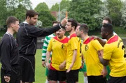 Schiedsrichter Michael Rost (Michael Epp, 2.v.l.) zeigt dem Fußballstar Emre Yilmaz (Olgu Caglar, 3.v.r.) von der Spielvereinigung Lübeck die rote Karte. (Mit im Bild Komparsen).