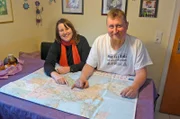 Verena und Patrick Fuchs zeigen im Haus der Großeltern in Leutkirch auf der Karte ihre geplante Reiseroute.