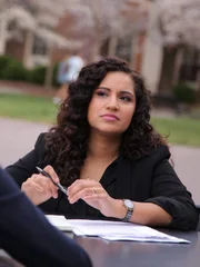 Fatima Silva listens to expert Dr. Stacy Wetmore at a park table.