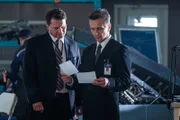 Ein russischer Ermittler (gespielt von Val Ovtcharov, rechts) studiert Luftaufnahmen der Absturzstelle von Aeroflot Nord Flug 821.
