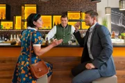 Miriam Stockl (Marisa Burger, l.) rätselt mit Kommissar Hansen (Igor Jeftić, r.) und Jo (Christian K. Schaeffer, M.), warum die Eröffnung der Trachtenboutique ausgefallen ist.