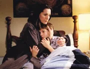 Kindermädchen Helen (Ana Alexander) tröstet den von Alpträumen geplagten Sam (Chris Kelly), der von seinen Erlebnissen im rumänischen Kinderheim traumatisiert ist.