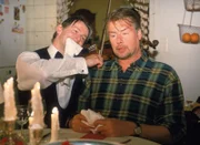 Horst (Frank Vockroth, re.) wollte Rita mit einem leckeren Abendessen und einem Stehgeiger (Max Herbrechter) überraschen, doch sie taucht einfach nicht auf. Er ahnt nicht, dass sie bei dem Versuch Bernie aus dem Crown-Markt zu befreien in einem Lüftungsschacht stecken geblieben ist.