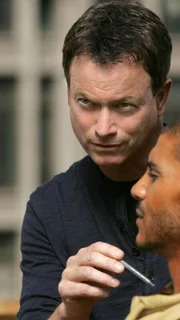 Detective Mac Taylor (Gary Sinise, l.) begutachtet die Leiche von Damion Brock (Kato James Bonner), der in sitzender Position auf dem Dach eines Hauses drapiert wurde.