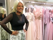 Tanja probiert ein Kleid mit asymmetrischen Details an.