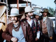Cole (Geoffrey Lewis, l.), Bart (Robert Donner, 2.v.r.) und Lonnie Younger (Timothy Scott, r.) sind mit ihrer Geisel Mr. Edwards (Victor French, 2.v.l.) nach Barton gekommen, um sich zu ergeben und die Belohnung zu kassieren.
