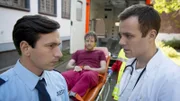 Dr. Tobias Falk (Bernhard Piesk, r.) versucht Schließer Loschmidt (Arnel Taci) davon zu überzeugen, ihn und seinen Patienten Michi Steinig (Daniel Aichinger, hinten) fahren zu lassen.