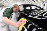 Bentley Motors Fabrik, Crewe UK: Ein Arbeiter wischt einen frisch lackierten Mulsanne ab und prüft ihn in der Lackiererei auf etwaige Unvollkommenheiten.