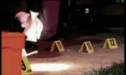 Am Tatort, wo die ehemalige Prostituierte June per Kopfschuß ermordet wurde, sucht die Polizei nach Patronenhülsen.
