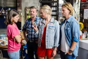 Pauline (Maike Johanna Reuter, l.) trifft es hart, als sie im Beisein von Ingo (André Dietz, 2.v.l.) und Finn (Christopher Kohn) von Marie (Cheyenne Pahde) erfährt, dass Damian sich mit Isabelle verlobt hat.