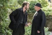 Sid Carter (Alex Price, l.) ist wütend auf Father Brown (Mark Williams, r.), der ihm heimlich gefolgt ist. Sid wurde gerade aus dem Gefängnis entlassen und verhält sich sehr merkwürdig. Als Father Brown ihn dabei erwischt, wie er sich mit einer Waffe auf eine Feier schleichen will, ist er schockiert.