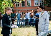 Sophie Pohlmann (Katrin Jaehne, l.) lässt sich von dem Spurensicherer Thomas Brandner (Yung Ngo, r.) den Tatort zeigen. Doch nicht nur die Kommissarin ist daran interessiert, was passiert ist, sondern auch einige Gaffer (Komparsen), die das Szenario filmen.