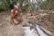 Rwanda, Akagera National Park. Ed eating a fish he has caught and cooked.