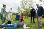 Pathologin Ela Atay (Sevda Polat, l.) und die Spurensicherin (Julia Angeli, 2.v.l.) geben den Kommissaren Andresen (Sophie Melbinger, M.) und Stadler (Dieter Fischer, r.) sowie Polizeihauptmeister Mohr (Max Müller, 2.v.r.) erste Informationen zur möglichen Todesursache des Opfers (Komparse).