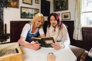 Dorfrichterin Heidi Rastl (links) und Sabine Sassy Holzinger (rechts) in Gössl lesen die Dorfchroniken.