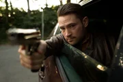 Goran (Mark Stepan) holding gun