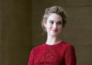British actress Lily James poses for photographers as she arrives for Changing Faces Gala Dinner, on Thursday, March 27, 2014 in London.