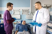 Assistenzarzt Olli Probst (Arne Kertész) und Dr. Matteo Moreau (Mike Adler, r.) nehmen Gilbert Tomke (Johannes Suhm, M.) in der Notaufnahme auf, der kurz zuvor aus rätselhaften Gründen in Ohnmacht gefallen ist.