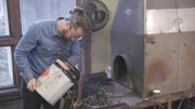 Ein Mann schüttet Kohle