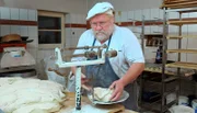Altbewährt: Mit einer "römischen" Schnellwaage portioniert Bäckermeister Günther Weber die einzelnen Laibe seines Bauernbrotes.