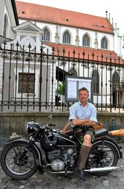 Stofferl Well auf seinem Motorrad vor der St. Ulrich Kirche.