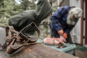 PORT PROTECTION, ALASKA- Amanda Makar listens closely to Gary Muehlberger as he demonstrates how to skin a beaver. (Photo Credit: National Geographic Channels/Joshua "J.J." Krehbiel)