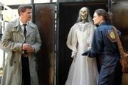 Booth (David Boreanaz, L) and Brennan (Emily Deschanel, R) examine a skeleton