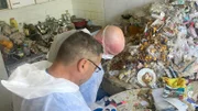 Ralf Gerstenlauer stands with his employee Jürgen Heck in a hoarder's apartment - Behind The Scenes