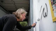 Jörg Hartmann paints a wall and removes graffiti