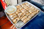 Eines der Traditionsgerichte Hanois: „Nem rán“ (Frittierte Frühlingsrollen) mit Dip-Sauce werden oft zusammen mit „Bún chả“ (gegrilltes Schweinefleisch in süß-saurer Soße) verkauft. Hier serviert im „Bún chả Mai Anh“, etwas außerhalb von Hanoi.