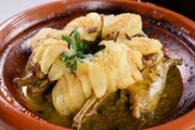 Tagine, geschmortes Fleisch und/oder Gemüse, zubereitet in einem konischen Kochgefäß (Tagine), ist vielleicht das beliebteste und traditionellste marokkanische Gericht. Hier wird es mit Wachteln und karamellisierten Birnen zubereitet.