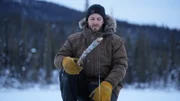 Johnny Rolfe fischt im Winter auf einem zugefrorenen See nach Nahrung für den Eigenbedarf. (National Geographic für Disney/Tyler Colgan)