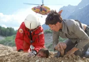 Biggi Schwerin (Sabine Petzl) und Dr. Mark Harland (Urs Remond, li.) bergen Enrico Contini (Tom Mikulla), der in einer Baugrube von tonnenweise Sand verschüttet wurde.