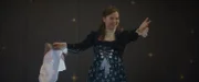 Josie (Yuki Sutton) performt mit der Zauberkraft von Theo und Darius und hat dabei Theo in ein Papierpüppchen verwandelt.