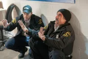 Für die als Security-Beamte verkleideten Ermittler Jay Halstead (Jesse Lee Soffer, l.) und Alvin Olinsky (Elias Koteas) wird es brenzlig. Kriminelle drohen sie bei einem Drogenraub zu erschießen.
