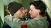 Melanie (Sigrid M. Schnückel) wird in den Gerichtssaal geführt. Ihr kranker Ehemann Mike (Tino Blazejewski) kommt überraschend aus dem Haftkrankenhaus vorbei und schenkt ihr eine Rose.