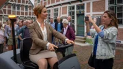 Bürgermeisterin Heide Schulze (Anne Roemeth, l.) weiht bei ihrem öffentlichen Termin stolz die neue Kehrmaschine für Jork ein. Für den Artikel in der Altländer Zeitung dokumentiert Beke Rieper (Felicitas Woll, r.) dies mit ihrem Handy.