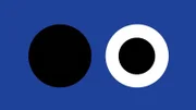 Since each of the inner dots disappears when surrounded by it's own color, which happens at different times for the two circles, your brain gets tricked into seeing an alternating pattern.