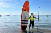 Judith Rakers probiert aus, wie sie auf einem Stand-up-Paddling-Board Yoga machen kann, ohne herunterzufallen.