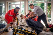 Alexander Schmölzer (Peter Davor, r.) hat seine Frau Laura (Stephanie Japp) in ihrem Haus gefesselt vorgefunden. Dr. Haase (Fabian Harloff, 2.v.r.) kümmert sich um die unter Schock stehende Frau.
