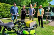 E-Bike-Zubehör im Alltags-Check: Funktioniert der Wocheneinkauf der Familie ten Brink künftig auch ohne Auto? „Ausgerechnet“-Moderator Daniel Aßmann (2.v.r.) und Hauswirtschaftsmeisterin Yvonne Willicks (r) stellen das Ehepaar (links, 2.v.l.) auf die Probe. Bleiben Eier, Melone, Sektflasche und Co. intakt?