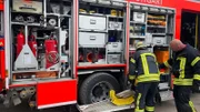Die Feuerwehrleute bereiten das Löschfahrzeug vor.