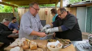 Kleingartenchef Alex (re.) verwöhnt seine Gäste mit geräucherten Forellen - inklusive Holzofenbrot.; Kleingartenchef Alex (re.) verwöhnt seine Gäste mit geräucherten Forellen – inklusive Holzofenbrot.