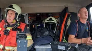 Two firefighters on the way to a traffic accident.
