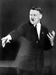 Adolf Hitler in Rednerpose, fotografiert von Heinrich Hoffmann im Jahr 1927. Viele Nazis suchten nach germanischen Ursprüngen und warfen Judentum und Christentum die angebliche Ausrottung germanischer Kulte während der Hexenverfolgung vor.