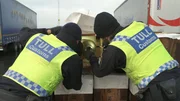 Grenzschutzbeamte inspizieren den Inhalt eines Lastwagens