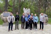Die fünf "Kriegie Kids" und ihre polnischen Gastgeber am Denkmal für das Kriegsgefangenenlager im polnischen Tychowo.