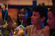 Châu (Ngoc Nhi Ha Tran, l.), Tom (Noah Bailey, M.) und Liv (Marie Wahl, r.) freuen sich: Die Direktorin hat der ganzen Klasse einen Gutschein fürs Bowlingcenter geschenkt.