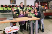 Checker Tobi mit seiner Herausforderin Karolin von der Freiwilligen Feuerwehr München und mit Nachwuchs-Feuerwehrleuten, die ihm beim CheXperiment helfen.