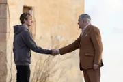 Alex Rider (Otto Farrant, l.) macht als Teil des Empfangskomitees die Bekanntschaft mit Max Grendel (Kevin McNally, r.) – doch das ist für ihn nur der Anfang.
